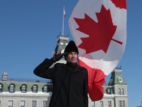 Royal Military College Officer Cadet Kevin Greenwell salutes the Canadian flag as it is raised at a ceremony marking the flag's 50th anniversary Friday, Feb. 13, 2015 in Kingston.
ELLIOT FERGUSON/KINGSTON WHIG-STANDARD/QMI AGENCY