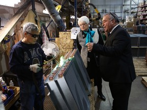 Pat Occhicone, president and chief executive officer of Direct Coil, and Treasury Board president Liz Sandals watch Edna Quintana weld during a tour of the factory, which on Friday announced plans for a $2.7M expansion. (Elliot Ferguson/The Whig-Standard)
