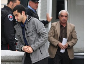 Hamed Shafia (foreground) and his father Mohammad enter court in Kingston in November 2011 to start the third week of their first-degree murder trial. (Ian MacAlpine/Whig-Standard file photo)