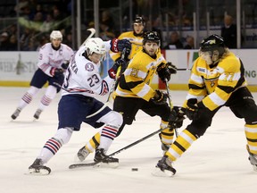 Oshawa Generals centre Jack Studnicka, left, tries to get past Kingston Fontenacs' Ryan Cranford, centre, and Eemeli Rasanen during the first period of the Generals' 5-0 Ontario Hockey League win in Kingston on Friday night at the Rogers K-Rock Centre. (Elliot Ferguson/The Whig-Standard)