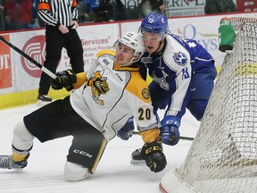 Michael Pezzetta, right, of the Sudbury Wolves, pushes Connor Schlichting, of the Sarnia Sting, to the ice during OHL action at the Sudbury Community Arena in Sudbury, Ont. on Friday February 3, 2017. John Lappa/Sudbury Star/Postmedia Network