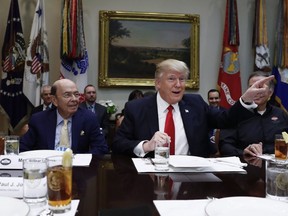 President Donald Trump, centre, and Commerce Secretary-designate Wilbur Ross, left, talk to media before a lunch meeting in the Roosevelt Room of the White House in Washington, Thursday, Feb. 2, 2017. (THE CANADIAN PRESS/AP)