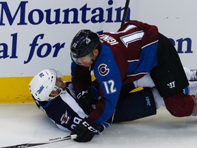 Colorado Avalanche right winger Jarome Iginla knocks over Winnipeg Jets defenceman Toby Enstrom while pursuing the puck during an NHL game on Feb. 4, 2017. (AP Photo/David Zalubowski)