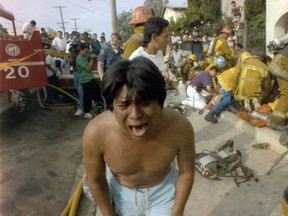 In this May 3, 1993 file photo, a young man weeps after seeing a dead child in front of an apartment house in the Westlake district that was devastated by fire in Los Angeles. ( J.Albert Diaz/Los Angeles Times via AP)
