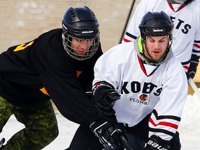 Michael Burgess, left, of the Crown Verity-sponsored CFB Trenton team challenges Koets Plumbing's James Belej during a round-robin game of the sixth-annual Pond Hockey Classic Saturday in Batawa. Thirty teams competed and proceeds will be divided equally between the Trenton Memorial Hospital Foundation and Wounded Warriors Canada. See Monday's print edition of The Intelligencer for a photo spread from the tournament.