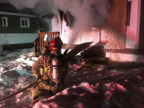 Firefighters tackle a blaze at an abandoned mobile home on Minto Street in Penhold, Alta.