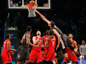 Nets centre Brook Lopez (11) lands a basket as he goes over a group of Raptors defenders including Jonas Valanciunas (17) and DeMarre Carroll (5) during first half NBA action in New York on Sunday, Feb. 5, 2017. (Kathy Willens/AP Photo)