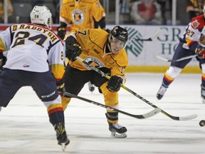 Kingston Frontencs’ Justin Pringle flips the puck past Erie Otters’ Darren Raddysh during the second period of Ontario Hockey League action at the Rogers K-Rock Centre on Sunday. (Steph Crosier/The Whig-Standard)