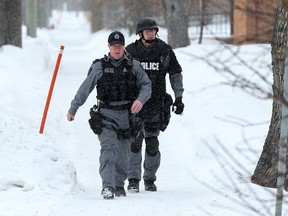 Members of the Winnipeg Police Service tactical unit walk down Midwinter Avenue between Brazier Street and Levis Street in the Elmwood area of Winnipeg on Sun., Feb. 5, 2017. Police tweeted that they were investigating a serious incident there. On Monday, Feb. 6, 2017, Winnipeg Police Service announced that six individuals were facing drug related charges after police responded to the 200 block of Midwinter Avenue on Sunday afternoon regarding a male possibly armed with a gun. Kevin King/Winnipeg Sun/Postmedia Network