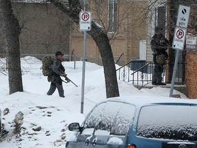 Members of the Winnipeg Police Service tactical unit enter an apartment building on Midwinter Avenue between Brazier Street and Levis Street in the Elmwood area of Winnipeg on Sun., Feb. 5, 2017. Police tweeted that they were investigating a serious incident there. It is unknown if the scene is connected to a serious incident earlier in the day on Gateway Road and Munroe Avenue where a taxicab was shot at. Kevin King/Winnipeg Sun/Postmedia Network