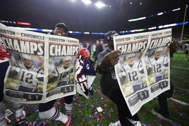 New England Patriots players celebrate with newspapers after their overtime win in the NFL Super Bowl 51 football game against the Atlanta Falcons, Sunday, Feb. 5, 2017, in Houston. (AP Photo/Tony Gutierrez) ORG XMIT: NFL382