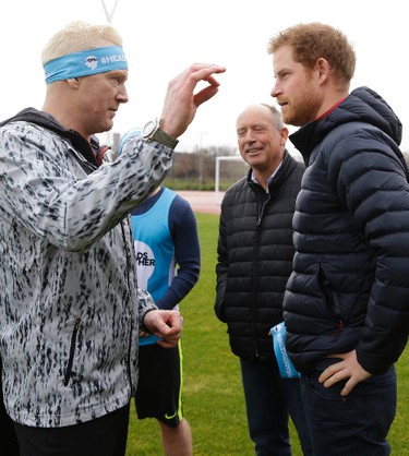 Prince Harry, right, speaks to former British Olympic athlete Iwan Thomas as he prepares to take part in a short relay race, during a training event to promote the charity Heads Together, at the Queen Elizabeth II Park in London, Sunday, Feb. 5, 2017. (AP Photo/Alastair Grant, Pool)