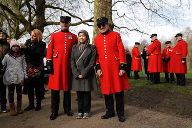 A tourist poses for a photograph with Chelsea Pensioners before the King's Troop Royal Horse Artillery arrived to stage a 41-Gun Royal Salute to celebrate Britain's Queen Elizabeth II's Sapphire Jubilee, marking the 65th anniversary of her accession to the throne in Green Park, London, Monday, Feb. 6, 2017. The 90-year-old queen has become the first British monarch to reach the milestone of 65 years on the throne. (AP Photo/Matt Dunham)
