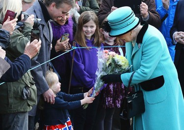 Britain's Queen Elizabeth II stops to receive flowers from 3-year old Jessica Atfield, after the queen and her husband Duke of Edinburgh, attended a church service at St Peter and St Paul church in West Newton, England, Sunday Feb. 5, 2017.  The Queen is to make history on Monday Feb. 6, when she becomes the first British monarch to reach the Sapphire Jubilee, marking the 65th. anniversary of her accession to the throne. (Gareth Fuller/PA via AP)