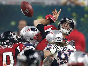 Atlanta Falcons QB Matt Ryan gets roughed-up by New England Patriot defenders during Sunday's Super Bowl in Houston. (Sporting News)