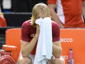 Canada's Denis Shapovalov looks on from behind a towel after the match was declared forfeited by Umpire Arnaud Gabas of France after he was hit in the face with a ball fired by Shapovalov during Davis Cup World Cup action opn Feb. 5, 2017. (THE CANADIAN PRESS/Justin Tang)