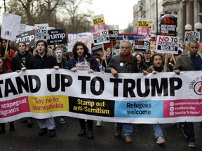 People hold a banner as they take part in a protest march in London, against U.S. President Donald Trump's ban on travellers and immigrants from seven predominantly Muslim countries entering the U.S., Saturday, Feb. 4, 2017. Thousands of protesters have marched on Parliament in London to demand that the British government withdraw its invitation to U.S. President Donald Trump. (AP Photo/Matt Dunham)