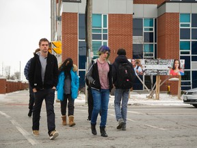 Students cross Oxford Street in London toward Fanshawe College with the new student apartment building The Residence on First visible behind them. (Mike Hensen/The London Free Press)