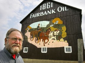 Charlie Fairbank stands in front of his barn painted with a mural depicting the beginning of Fairbank Oil more than a century ago. He still pumps oil from the original site. The Oil Springs Industrial Landscape, a site that includes the Fairbank Oil properties and the Oil Museum of Canada, has been submitted to Parks Canada to be considered for World Heritage site designation. (FILE PHOTO)