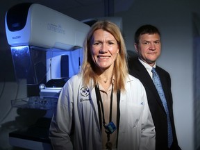 Dr. Jean Seely, Head of Breast Imaging at the Civic Hospital's  Breast Health Centre in Ottawa, and her brother, Dugald Seely, a naturopathic doctor and Executive Director of the Ottawa Integrative Cancer Centre, stand beside a mammography machine that has been fitted with hardware capable of 3D imaging.