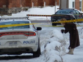 A woman talks with Barrie police after two men were found dead on William Street early Wednesday morning. BOB BRUTON photo