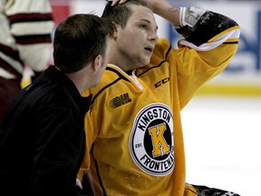 Kingston Frontenacs' Cody Caron is tended to by athletic therapist Ryan Bennett after receiving a head check from  Peterborough Petes' Alex Black during Ontario Hockey League action at the Rogers K-Rock Centre. (Ian MacAlpine/The Whig-Standard)
