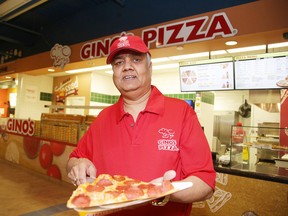 Anil Verma, franchise owner of Gino's Pizza, shows off a slice outside his location in the Rainbow Centre on Wednesday. (Gino Donato/Sudbury Star)