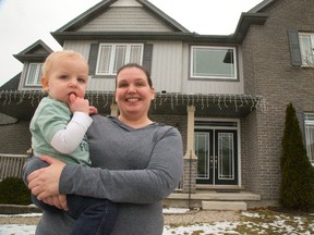 Tori Powell, and her son, Grayson, 1, have a clear view of Highway 401 running just south of their neighbourhood in Woodstock. Powell and her husband moved to Woodstock after living in Burlington, after a job transfer took him from Toyota?s Cambridge plant to its operation in Woodstock. (Mike Hensen/London Free Press)