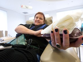 Jill Mabey, who has been donating blood on-and-off for 20 years, shows the bag of blood she donated at a Canadian Blood Services clinic in London, Ont. on October 26, 2016. The organization has changed its guidelines, requiring female donors to wait 12 instead of the previous 8 weeks between donations in an effort to prevent iron deficiencies. (Craig Glover/Postmedia Network)