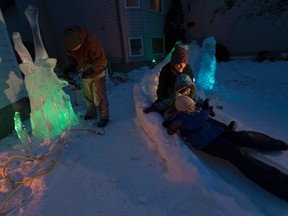 Kelly Davies is an ice carver who has taken leftover ice and created a 40-foot slide for his children Anna, 7 (r) and Julia,4, (m) and wife Kathy (l) taken on Thursday February 9, 2017 in Sherwood Park. Every year he has a new creation, but this is his biggest feat yet.  Greg  Southam / Postmedia