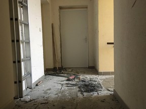 Wreckage of an entrance of an apartment building after a raid of a French anti-terrorist police unit in Clapiers, southern France, Friday, D-Feb. 10, 2017. Anti-terrorism forces arrested four people Friday in southern France, including a 16-year-old girl, and uncovered a makeshift laboratory with the explosive TATP and other ingredients for fabricating a bomb. France's top security official said the raid thwarted an "imminent attack." (AP Photo/Claude Paris)