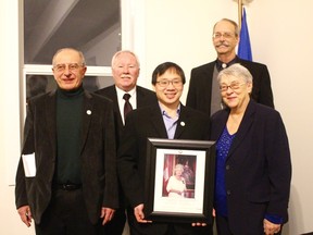 Stony Plain Mayor William Choy receives a portrait of Queen Elizabeth II from the Hills of Hope Historical Society on Feb. 6 (top right), then invites his fellow council members to gather around their new gift.  - Photo by Mitch Goldenberg, Reporter/Examiner