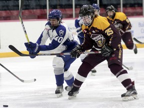 Marc-Andre Quevillion, left, of the Sudbury Nickel Capital Wolves races for a loose puck ahead of Timmins Majors defenceman Shane Benoit in Great North Midget League action at the McIntyre Arena on Saturday evening. The Nickel Caps showed no mercy for the Majors, skating to a 10-0 victory. Benjamin Aube/Postmedia Network