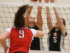 Alexa Merchant and Amy Anger of Clarke Road successfully bock a tip by Medway's Haley Padbury during their senior girls volleyball playoff match at Saunders on Friday February 10, 2017. (MIKE HENSEN, The London Free Press)