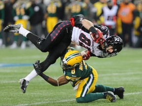 RedBlacks’ Greg Ellingson is taken down by Eskimos’ Cauchy Muamba. (Brian Donogh/Postmedia Network)