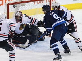 Blackhawks goalie Corey Crawford loses sight of the puck as Jets centre Andrew Copp attempts to capitalize at the MTS Centre last night. (The Canadian Press)
