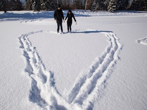 Brandon Day and Nikki Byrne draw a snow heart at Hawrelak Park on Valentine's Day in Edmonton, Alta., on Saturday, Feb. 14, 2014. They drew a heart out of freshly fallen powder snow while skating. Ian Kucerak/Edmonton Sun/ QMI Agency