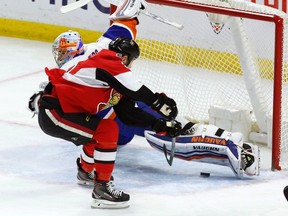 Senators’ Zack Smith scores on New York Islanders goalie Thomas Greiss during Saturday's game. (THE CANADIAN PRESS)