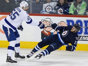 Jets' Nik Ehlers gets rocked by Tampa Bay's Braydon Coburn during Saturday night's game. (THE CANADIAN PRESS)
