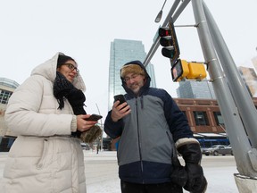 University of Alberta researcher Rob Shields (right) and intern Nathalia Osorio are using smartphone applications to study walking patterns and traffic light signalling. They are seen in downtown Edmonton on Monday, February 6, 2017. Ian Kucerak / Postmedia