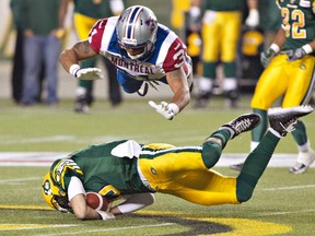 Montreal Alouettes' Winston Venable dives over Edmonton Eskimos quarterback Mike Reilly during a CFL game on Sept. 12, 2014. (THE CANADIAN PRESS/Jason Franson)