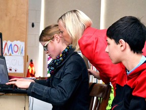 After Edith Schwalb-Gelbard finished speaking, students from each of the HPCDSB school had the chance to ask her a few questions about her experiences during the Second World War. Pictured, Sarah Rolph types out her question in the Skype chat window, as fellow student Keyan Renee-Neshaws (right) and St. Columban principal Dianne Vivian oversee her efforts. GALEN SIMMONS/MITCHELL ADVOCATE