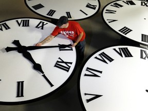 Dan LaMoore sizes hands for an 8-foot diameter silhouette clock at Electric Time Co., in Medfield, Mass.