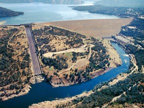 This June 23, 2005, aerial photo provided by the California Department of Water Resources shows Oroville Dam, Lake Oroville and the Feather River in the foothills of Sierra Nevada near Oroville, Calif. The concrete spillway that was undermined and developed huge holes in the last few days is at lower left. Release of water from the dam, the damaged spillway and the use of an earthen emergency spillway has caused a temporary evacuation on Sunday, Feb. 12, 2017, of thousands of people downstream. (Paul Hames/California Department of Water Resources via AP)