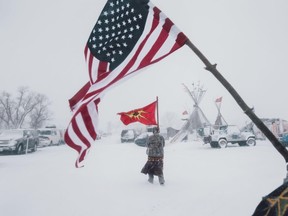 Veterans carry an American and a Mohawk Warrior Society flag through a storm. AMBER BRACKEN / SUPPLIED