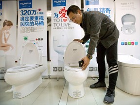 Zhong Jiye, a co-founder of Shenzhen Trump Industrial Co., demonstrates the use of one of his firm's high-end Trump-branded toilets at the company's offices in Shenzhen, China, on Monday, Feb. 13, 2017. (Mark Schiefelbein/AP Photo)