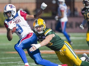 Montreal Alouettes' Kenny Stafford, left, is tackled by Edmonton Eskimos' Neil King during first half CFL football action in Montreal, Monday, October 10, 2016.