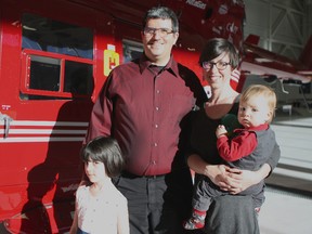 RCMP Cpl. Marcus Hirschfield is shown Tuesday with his wife, Holly Hirschfield and their two children Logan, 1, right, and Sophia, 5, at the STARS hangar at 1519 35 Ave. The family marked the first anniversary of STARS flying him to hospital after a crash on Feb. 14, 2013. (Claire Theobald)