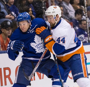 Toronto Maple Leafs right wing Connor Brown (12) battles New York Islanders defenseman Calvin de Haan (44)  in Toronto on Tuesday February 14, 2017. Craig Robertson/Toronto Sun/Postmedia Network