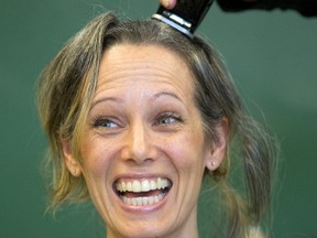 Infinity school principal Andrea Nair sheds her locks in solidarity with a pupil Gabrielle Co-Dyre, 7 who lost her hair in a 4-year fight with leukemia during a celebration at their school in London. (MIKE HENSEN, The London Free Press)